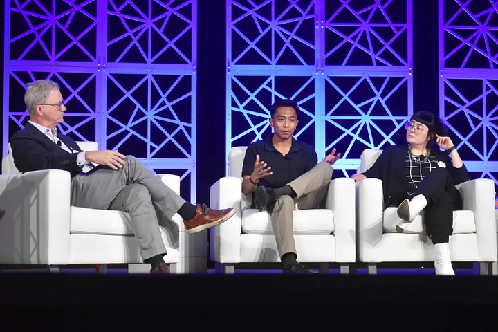 The moderator looks to his left as two SNAP members answer a question posed to them.