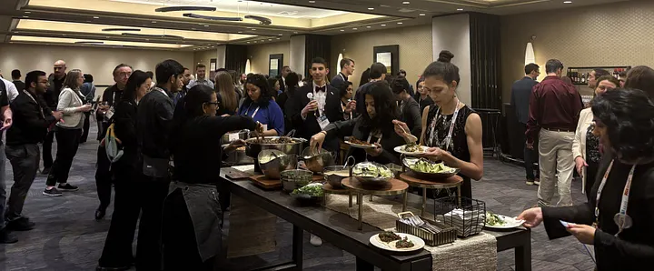 A large group of people are eating and drinking as they interact with each other.