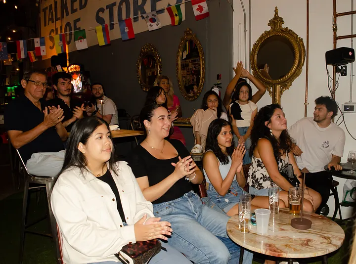 Community members seated at the brewery applauding a presentation